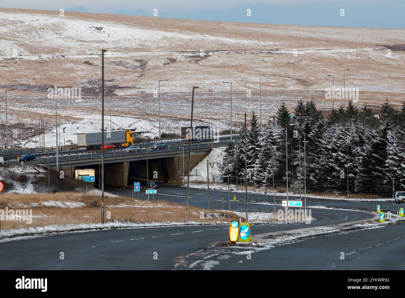 Ein schneebedecktes Ende des Tages auf der M62, als sie den höchsten Teil ihrer Länge in den Pennines zwischen Rochdale und Huddersfield überquert. Die M62 ist eine 107 Meilen (172 km) lange Trans-Pennine-Autobahn in Nordengland, die Liverpool und Hull über Manchester, Bradford, Leeds und Wakefield verbindet. Stockfoto
