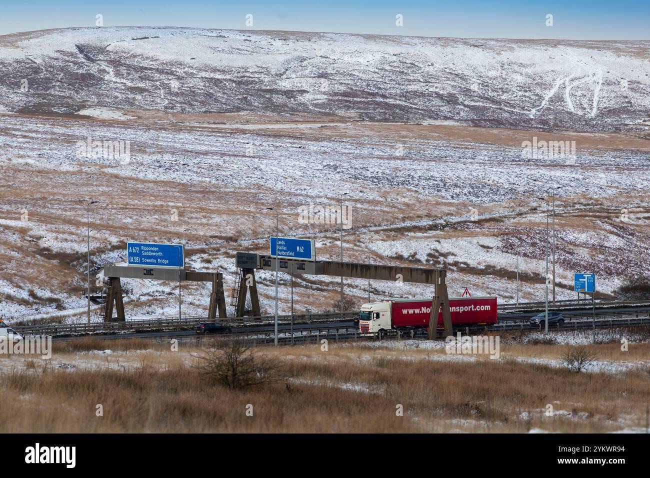 Ein schneebedecktes Ende des Tages auf der M62, als sie den höchsten Teil ihrer Länge in den Pennines zwischen Rochdale und Huddersfield überquert. Die M62 ist eine 107 Meilen (172 km) lange Trans-Pennine-Autobahn in Nordengland, die Liverpool und Hull über Manchester, Bradford, Leeds und Wakefield verbindet. Stockfoto