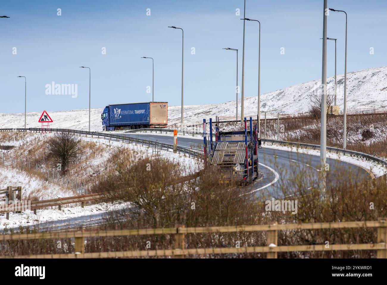 Ein schneebedecktes Ende des Tages auf der M62, als sie den höchsten Teil ihrer Länge in den Pennines zwischen Rochdale und Huddersfield überquert. Die M62 ist eine 107 Meilen (172 km) lange Trans-Pennine-Autobahn in Nordengland, die Liverpool und Hull über Manchester, Bradford, Leeds und Wakefield verbindet. Stockfoto