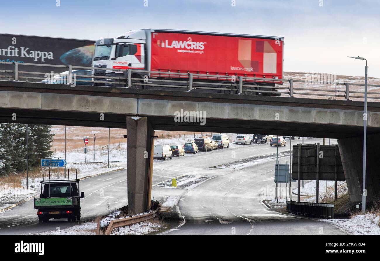 Ein schneebedecktes Ende des Tages auf der M62, als sie den höchsten Teil ihrer Länge in den Pennines zwischen Rochdale und Huddersfield überquert. Die M62 ist eine 107 Meilen (172 km) lange Trans-Pennine-Autobahn in Nordengland, die Liverpool und Hull über Manchester, Bradford, Leeds und Wakefield verbindet. Stockfoto