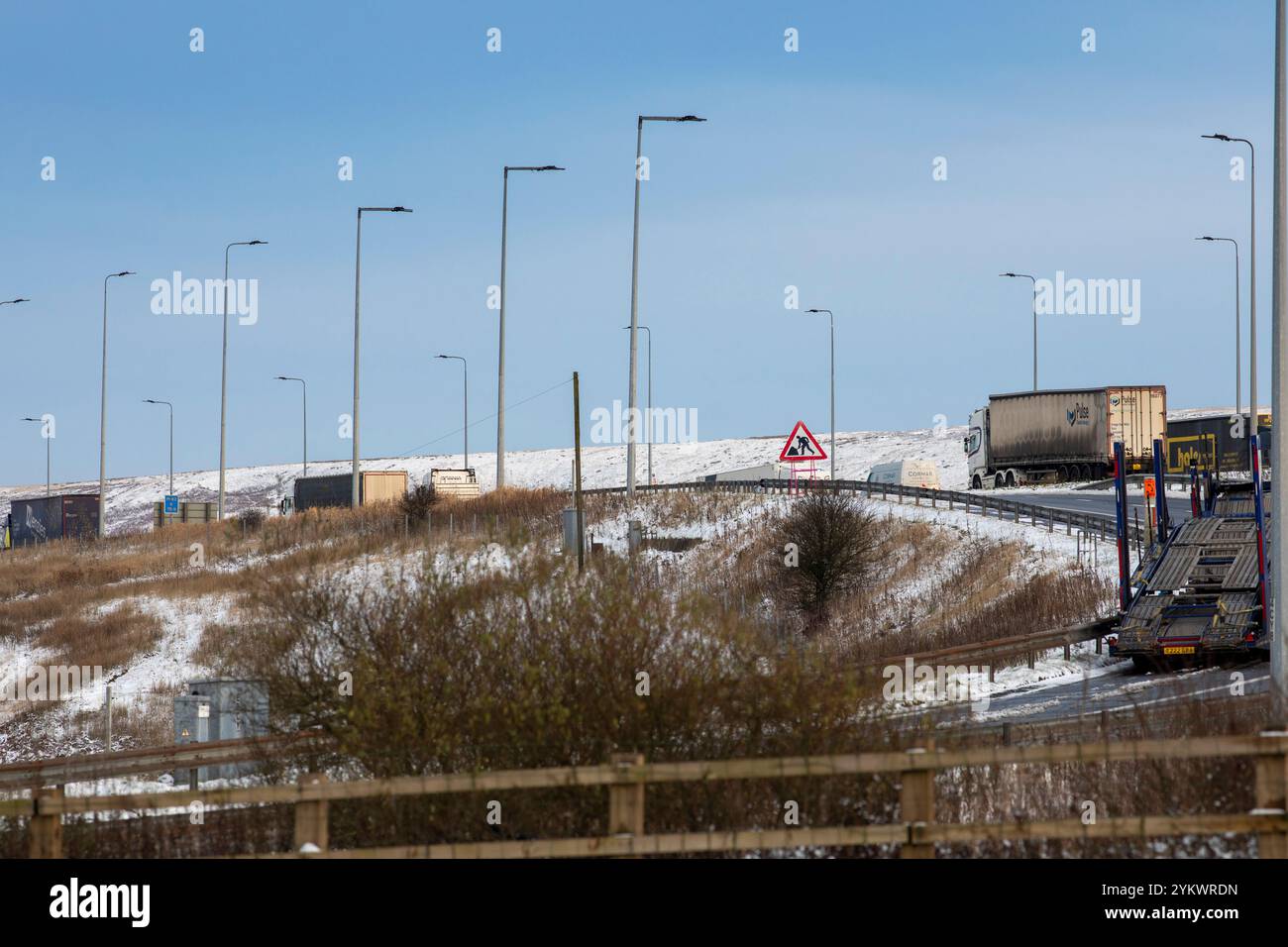 Ein schneebedecktes Ende des Tages auf der M62, als sie den höchsten Teil ihrer Länge in den Pennines zwischen Rochdale und Huddersfield überquert. Die M62 ist eine 107 Meilen (172 km) lange Trans-Pennine-Autobahn in Nordengland, die Liverpool und Hull über Manchester, Bradford, Leeds und Wakefield verbindet. Stockfoto