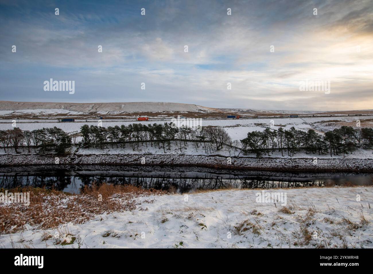 Ein schneebedecktes Ende des Tages auf der M62, als sie den höchsten Teil ihrer Länge in den Pennines zwischen Rochdale und Huddersfield überquert. Die M62 ist eine 107 Meilen (172 km) lange Trans-Pennine-Autobahn in Nordengland, die Liverpool und Hull über Manchester, Bradford, Leeds und Wakefield verbindet. Stockfoto