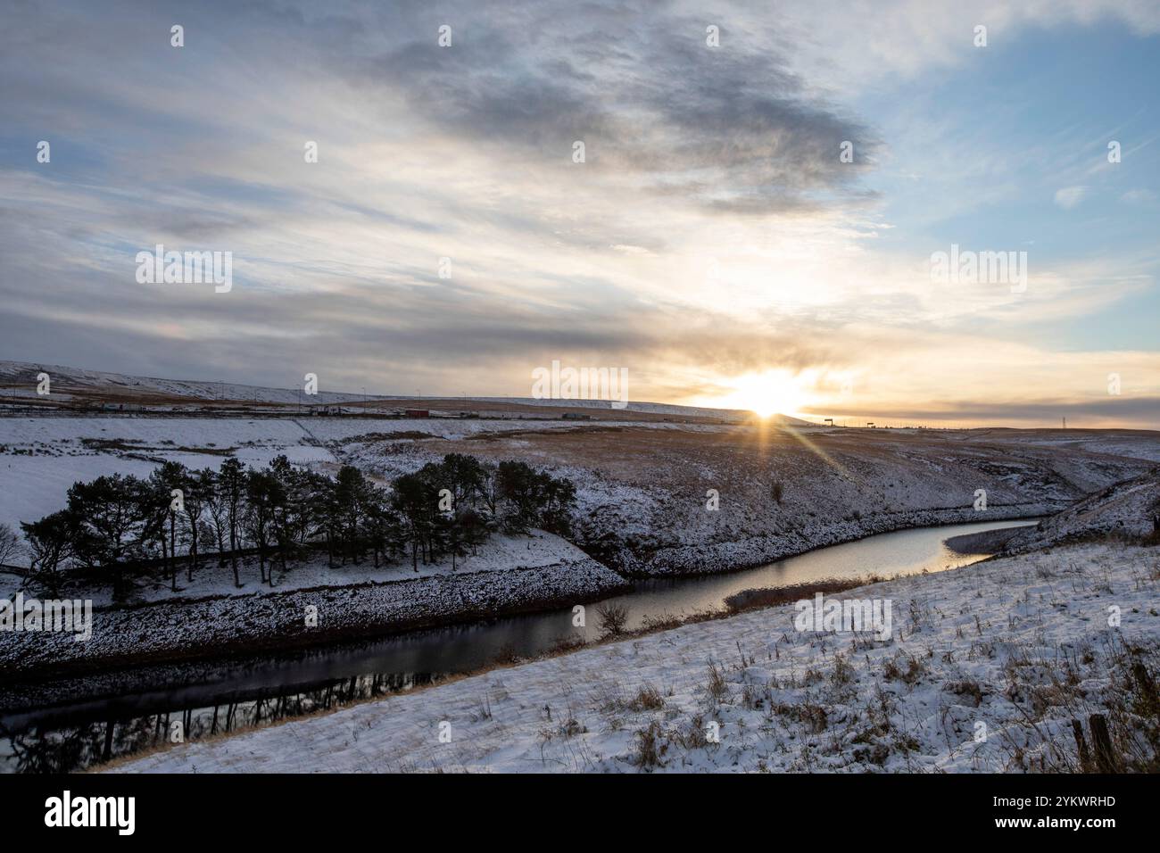 Ein schneebedecktes Ende des Tages auf der M62, als sie den höchsten Teil ihrer Länge in den Pennines zwischen Rochdale und Huddersfield überquert. Die M62 ist eine 107 Meilen (172 km) lange Trans-Pennine-Autobahn in Nordengland, die Liverpool und Hull über Manchester, Bradford, Leeds und Wakefield verbindet. Stockfoto