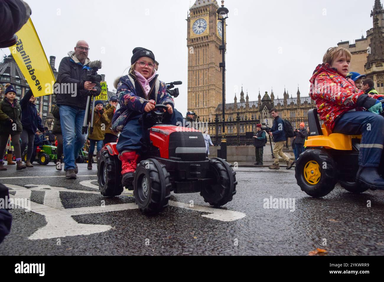 London, Großbritannien. November 2024. Bauernkinder fahren auf dem Parliament Square Spielzeugtraktoren, während Tausende von Bauern in Westminster gegen die Erbschaftssteuer protestieren. Quelle: SOPA Images Limited/Alamy Live News Stockfoto