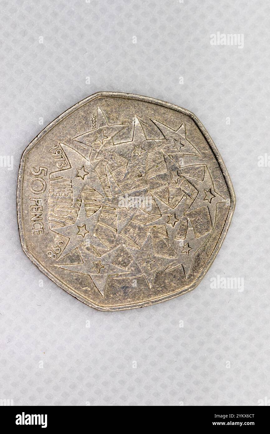 Ein Nahbild zeigt eine britische 50-Pence-Münze aus dem Jahr 1973 mit einem Design strahlender Sterne. Die Münze ist silberfarben und weist Gebrauchsspuren auf. Stockfoto