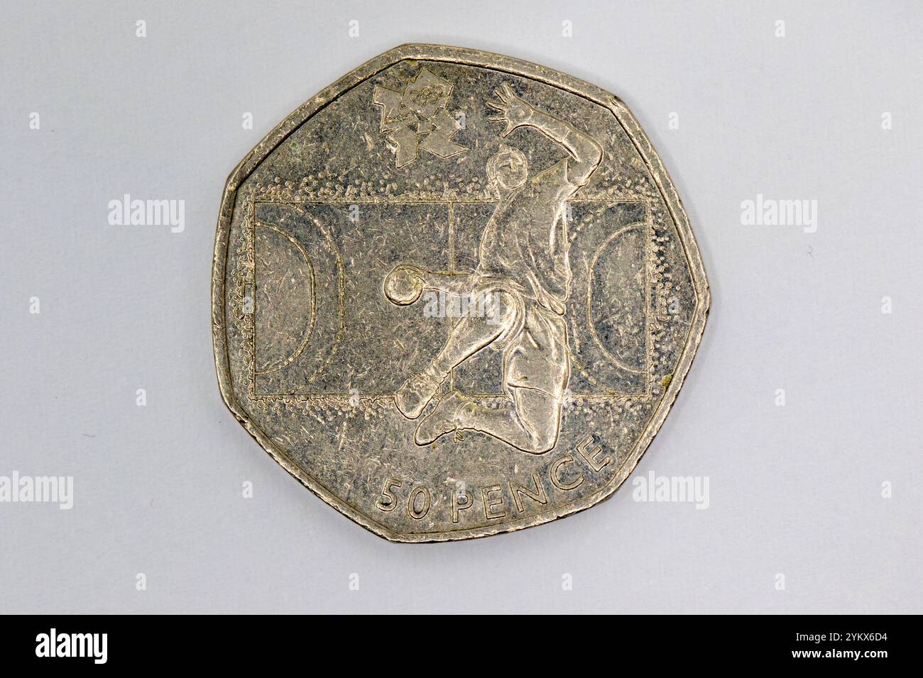 Nahaufnahme einer getragenen 50-Pence-Münze mit einem Handballspieler in Aktion vor der Kulisse des Spielfeldes. Das Münzdesign umfasst die London 2012 Olymp Stockfoto