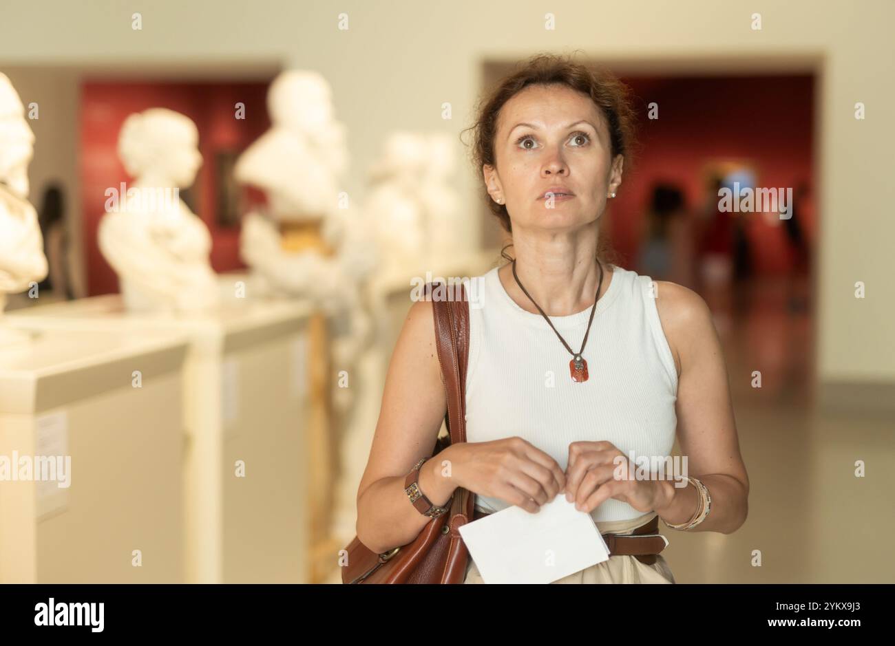 Positive Frau, die alte Basreliefs im alten Museum ansieht Stockfoto