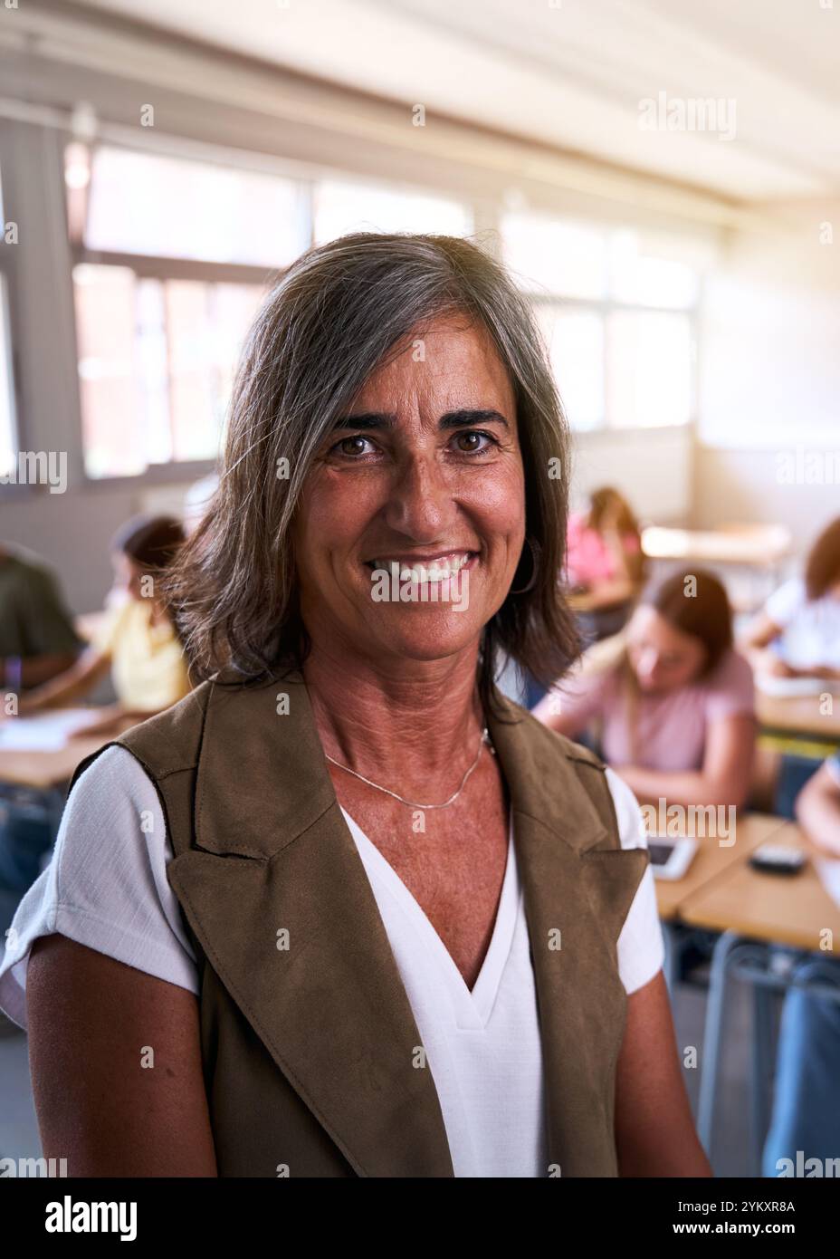 Porträt einer glücklichen, Reifen kaukasischen Lehrerin an der High School, die sich selbstbewusst im Unterricht posiert. Stockfoto