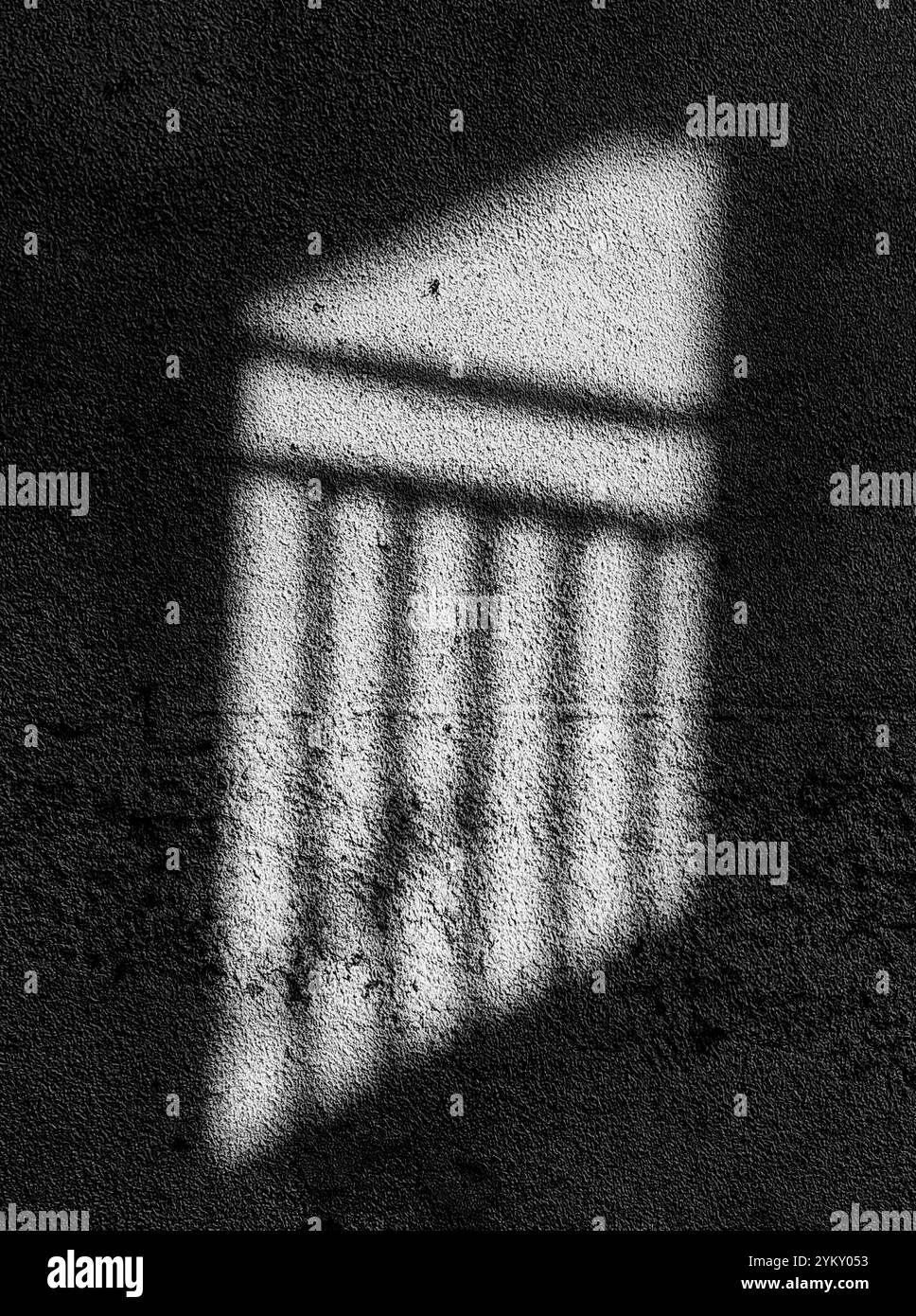 Sonnenlicht-Reflexion: Zaunschatten auf einer Mauer Stockfoto