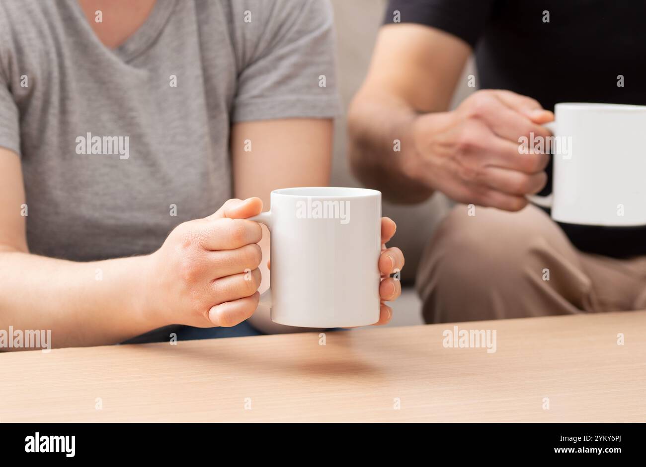 Ein Foto von einem jungen Paar, das eine Tasse Kaffee im Wohnzimmer zu Hause trinkt Stockfoto