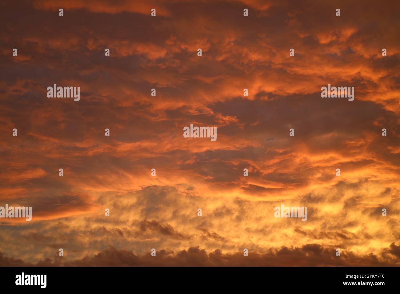 Niedrige Sturmwolken, die bei Sonnenuntergang in feurigen Tönen gemalt sind Stockfoto