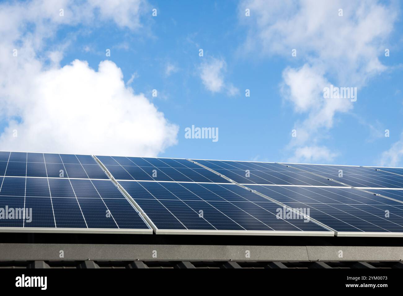 Luftaufnahme von Solarzellen vor bewölktem blauen Himmel. Konzept der alternativen Energie, nachhaltige Ressourcen. Haus mit Solarpaneelen, eigenständiges Foto Stockfoto