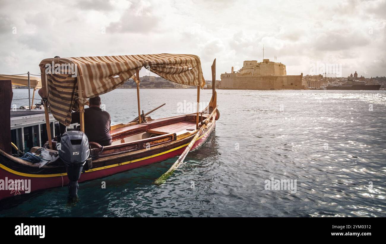 Dghajsa, traditionelles maltesisches Wassertaxi mit Fort St. Angelo im Hintergrund Stockfoto