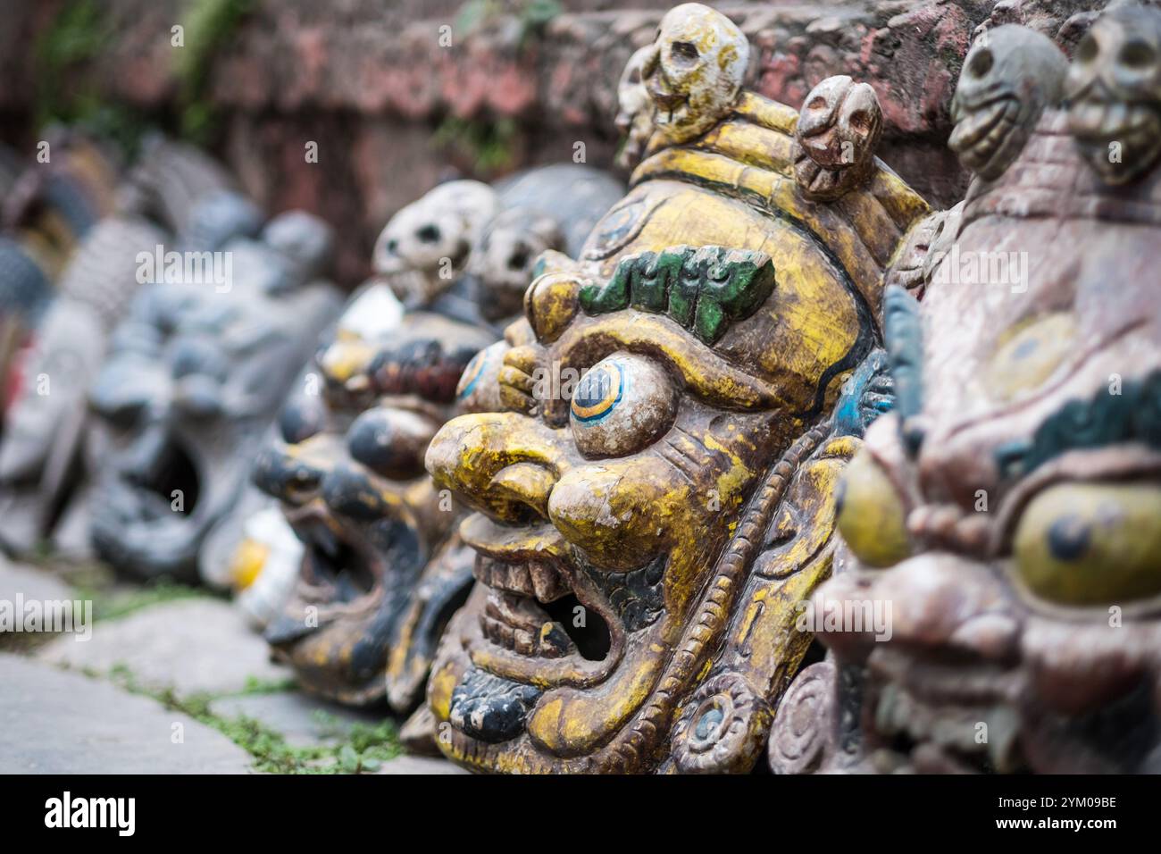 Souvenirmasken in der Nähe der Mauer auf dem nepalesischen Straßenmarkt, Kathmandu, Nepal. Stockfoto