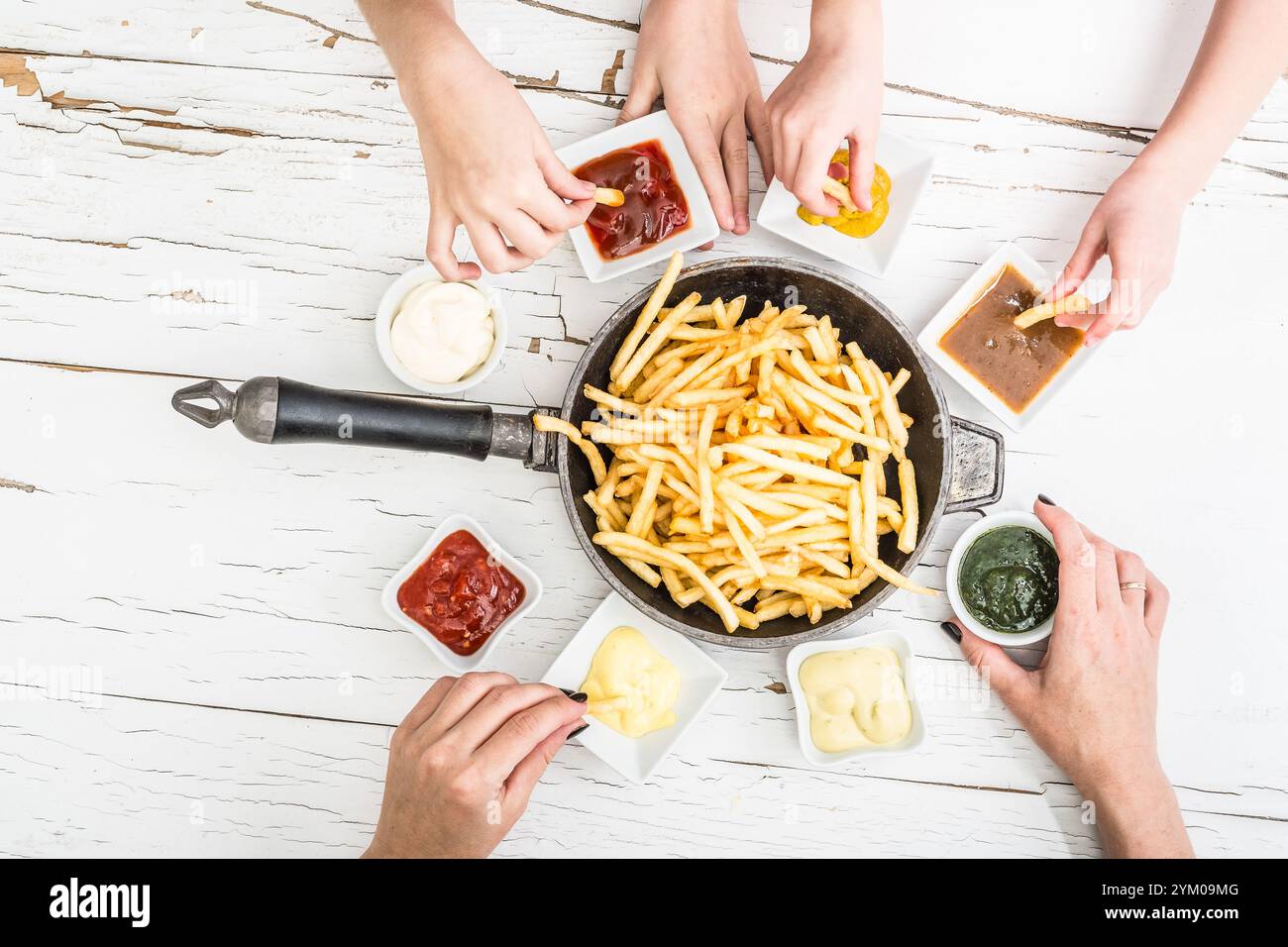 Die Familie hat Pommes frites mit verschiedenen Saucen zum Abendessen serviert. Draufsicht. Stockfoto