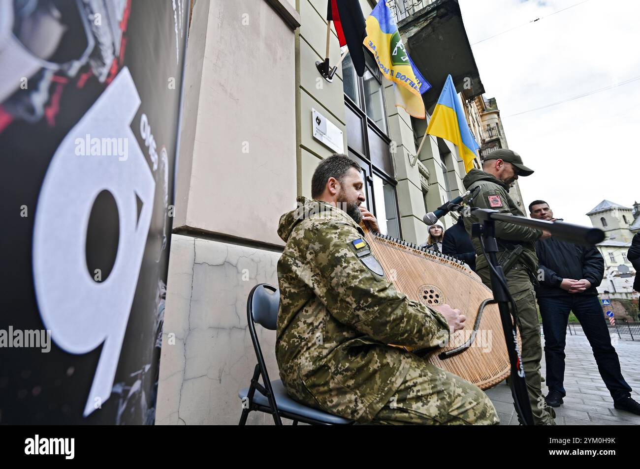 LEMBERG, UKRAINE - 15. NOVEMBER 2024 - Ein Mann in Militäruniform spielt die Bandura während der Eröffnung des ersten Rekrutierungszentrums der Ukraine der 67. Separaten Mechanisierten Brigade in Lemberg, Westukraine. Stockfoto