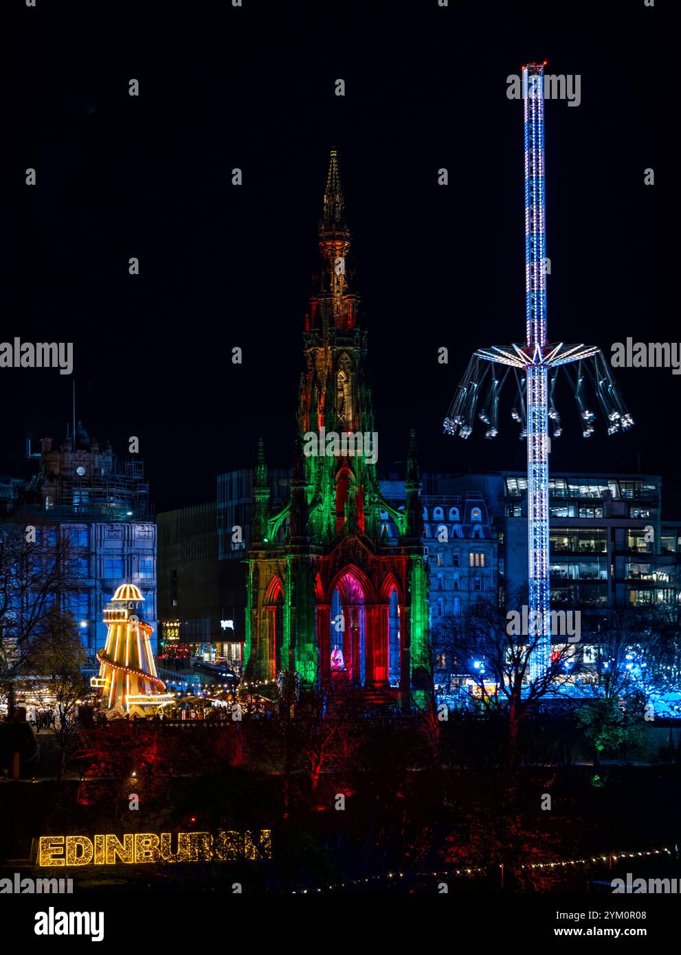 Weihnachtsstar-Flyer-Fahrgeschäfte und Scott Monument auf der Princes Street, beleuchtet bei Nacht, Edinburgh, Schottland, Großbritannien Stockfoto