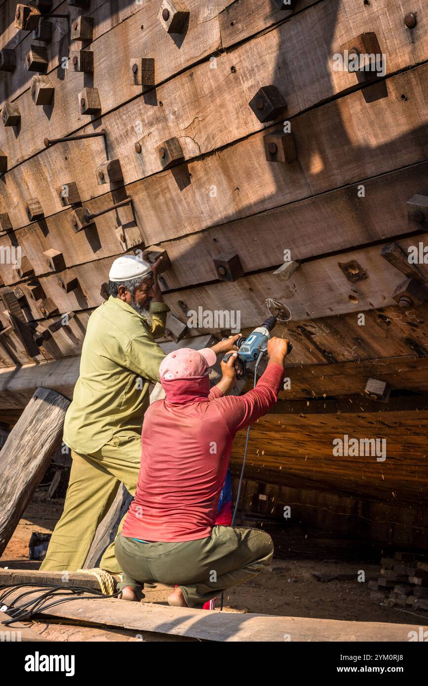 Schiffbauer arbeiten an einem Holzboot im Bau, Mandvi, Gujarat, Indien Stockfoto