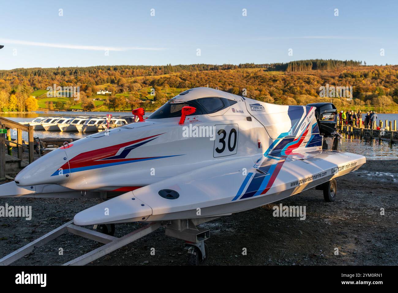 Ein elegantes, weißes Motorboot mit zwei Hüllen auf einem Anhänger an Land mit Aufdruck auf seinem Rumpf bei der Coniston Power Boat Records Week 2021 auf Coniston Water Stockfoto