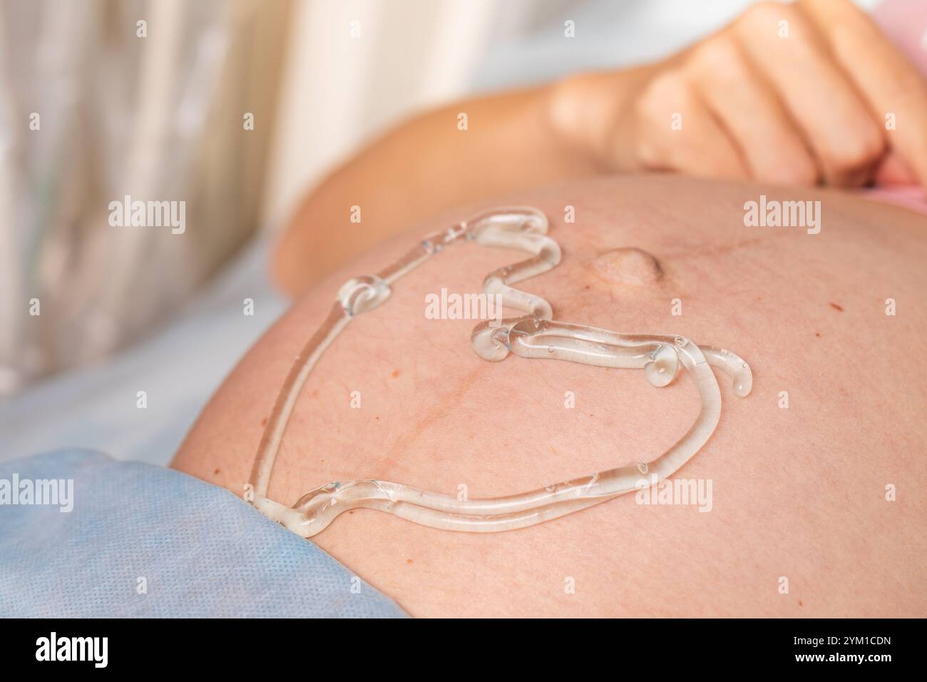 Nahaufnahme eines schwangeren Bauches mit herzförmigem Ultraschallgel, das die pränatale Versorgung und Schwangerschaft hervorhebt Stockfoto