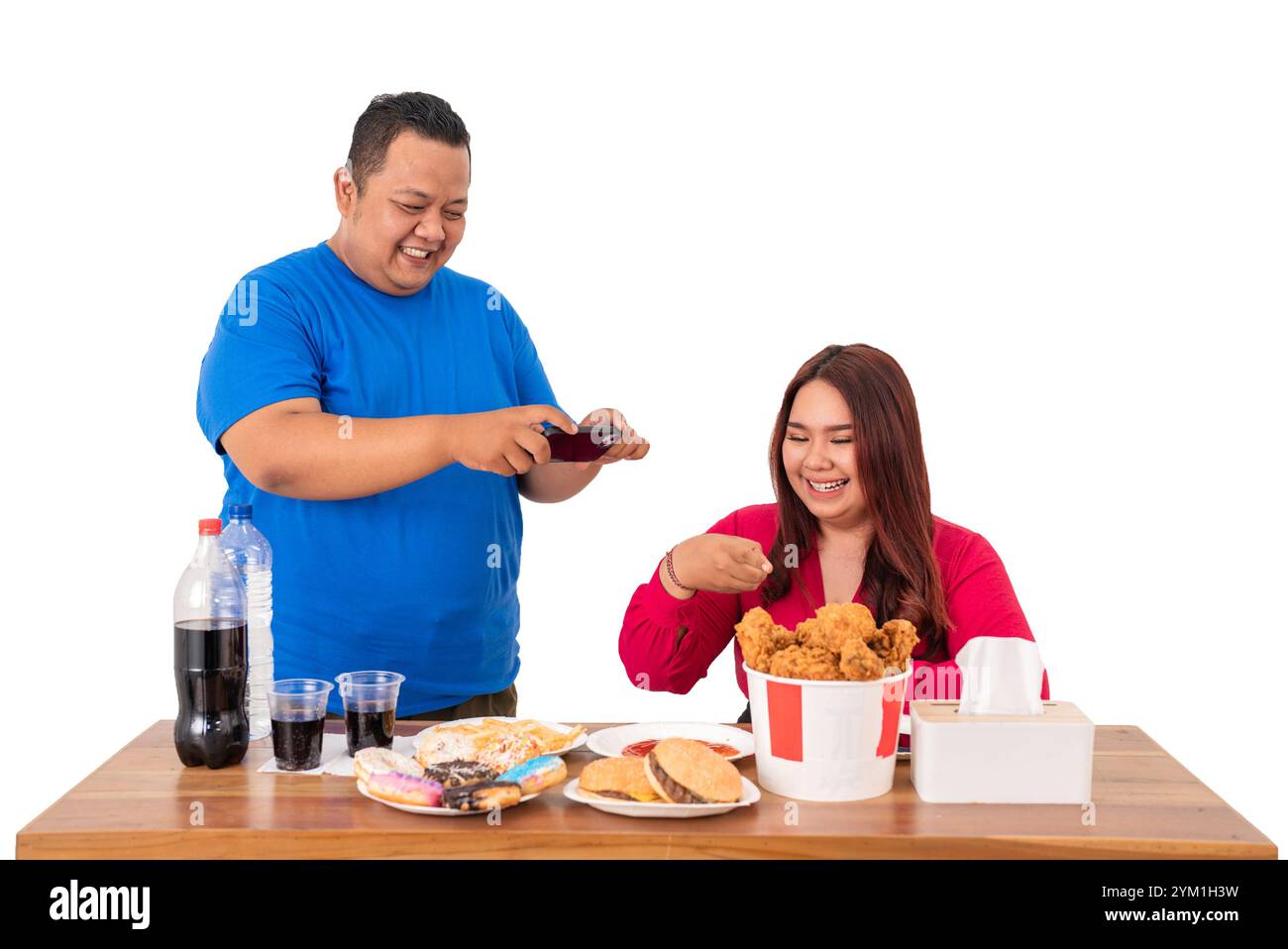 Eine Gruppe von Freunden, die gemeinsam Fast Food genießen, während sie mit einem Smartphone interagieren Stockfoto