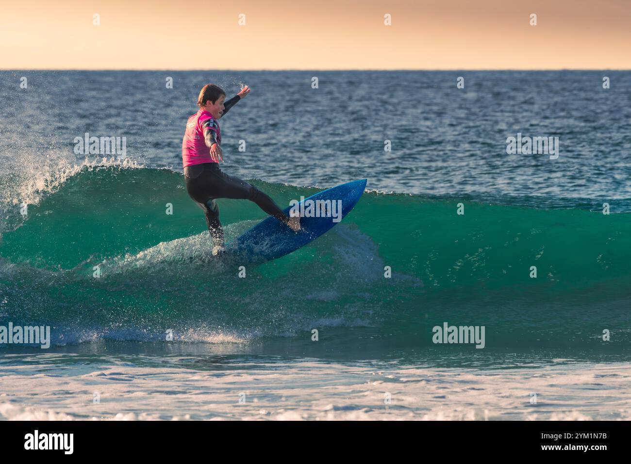 Ein junger Surfer, der auf einer Welle in Fistral in Newquay in Cornwall in Großbritannien in Europa reitet. Stockfoto