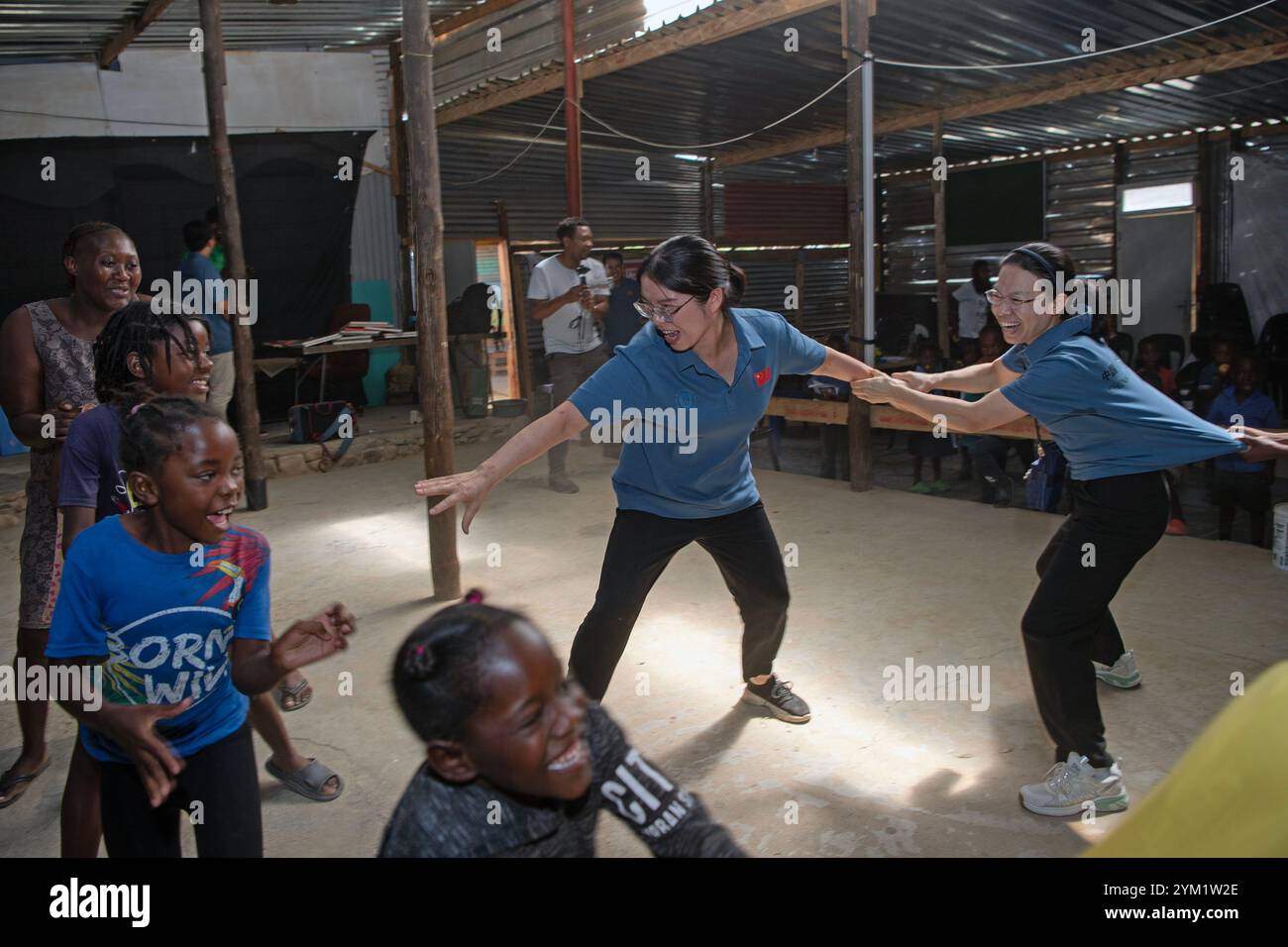 (241120) -- WINDHOEK, 20. November 2024 (Xinhua) -- Mitglieder des chinesischen medizinischen Teams spielen Spiele mit Kindern im Frans Nambinga Arts and Training Center in Windhoek, Namibia, 20. November 2024. Das 16. Chinesische Ärzteteam in Namibia führte am Mittwoch kostenlose medizinische Untersuchungen in der informellen Siedlung Havanna durch, einer der bevölkerungsreichsten Siedlungen Windhoeks, als sie sich dem Rest der Welt bei der Begehung des Weltkindertags anschlossen. Im Frans Nambinga Arts and Training Center führten Mitglieder des chinesischen medizinischen Teams medizinische Untersuchungen wie Wirbelsäulenuntersuchungen durch. Das Team hat den ch erzogen Stockfoto