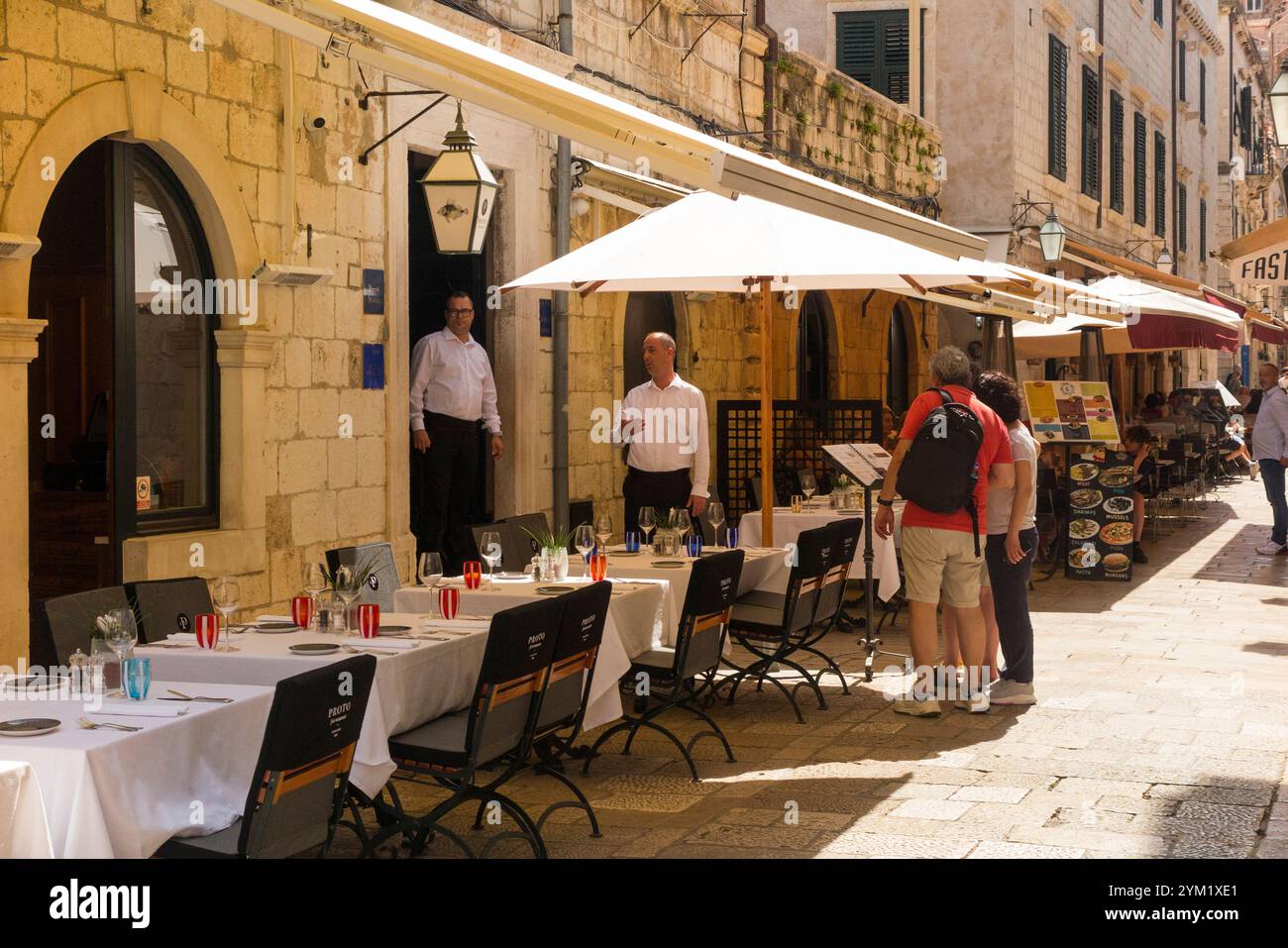 Außenbereich und Tische des Proto Fish Restaurant, Široka No 1, 20 000 Dubrovnik. Altstadt von Dubrovnik. Sommertag mit Mitarbeitern und potenziellen Kunden. Kroatien. (138) Stockfoto