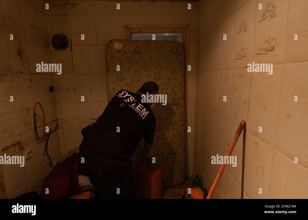 Alfafar, Spanien - 19. November 2024. Vicente, wohnhaft in Alfafar an der Torrente Avenue vor dem parque Alcosa, ließ sein Haus vollständig vom Wasserstrom untertauchen. Er zeigt die Höhe, die durch die Flut erreicht wurde, und zwei Fotos, die von derselben Stelle aufgenommen wurden, zum Fenster und zu den Straßenverhältnissen. In weniger als 15 Minuten stieg das Wasser um mehr als 1 Meter und das Motorrad (auf dem Foto) wurde weggefegt. Zu diesem Zeitpunkt hatten die Behörden noch nicht den roten Alarm gemeldet. Quelle: Roberto Arosio/Alamy Live News Stockfoto