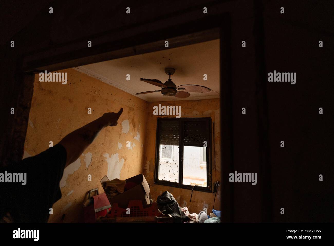 Alfafar, Spanien - 19. November 2024. Vicente, wohnhaft in Alfafar an der Torrente Avenue vor dem parque Alcosa, ließ sein Haus vollständig vom Wasserstrom untertauchen. Er zeigt die Höhe, die durch die Flut erreicht wurde, und zwei Fotos, die von derselben Stelle aufgenommen wurden, zum Fenster und zu den Straßenverhältnissen. In weniger als 15 Minuten stieg das Wasser um mehr als 1 Meter und das Motorrad (auf dem Foto) wurde weggefegt. Zu diesem Zeitpunkt hatten die Behörden noch nicht den roten Alarm gemeldet. Quelle: Roberto Arosio/Alamy Live News Stockfoto