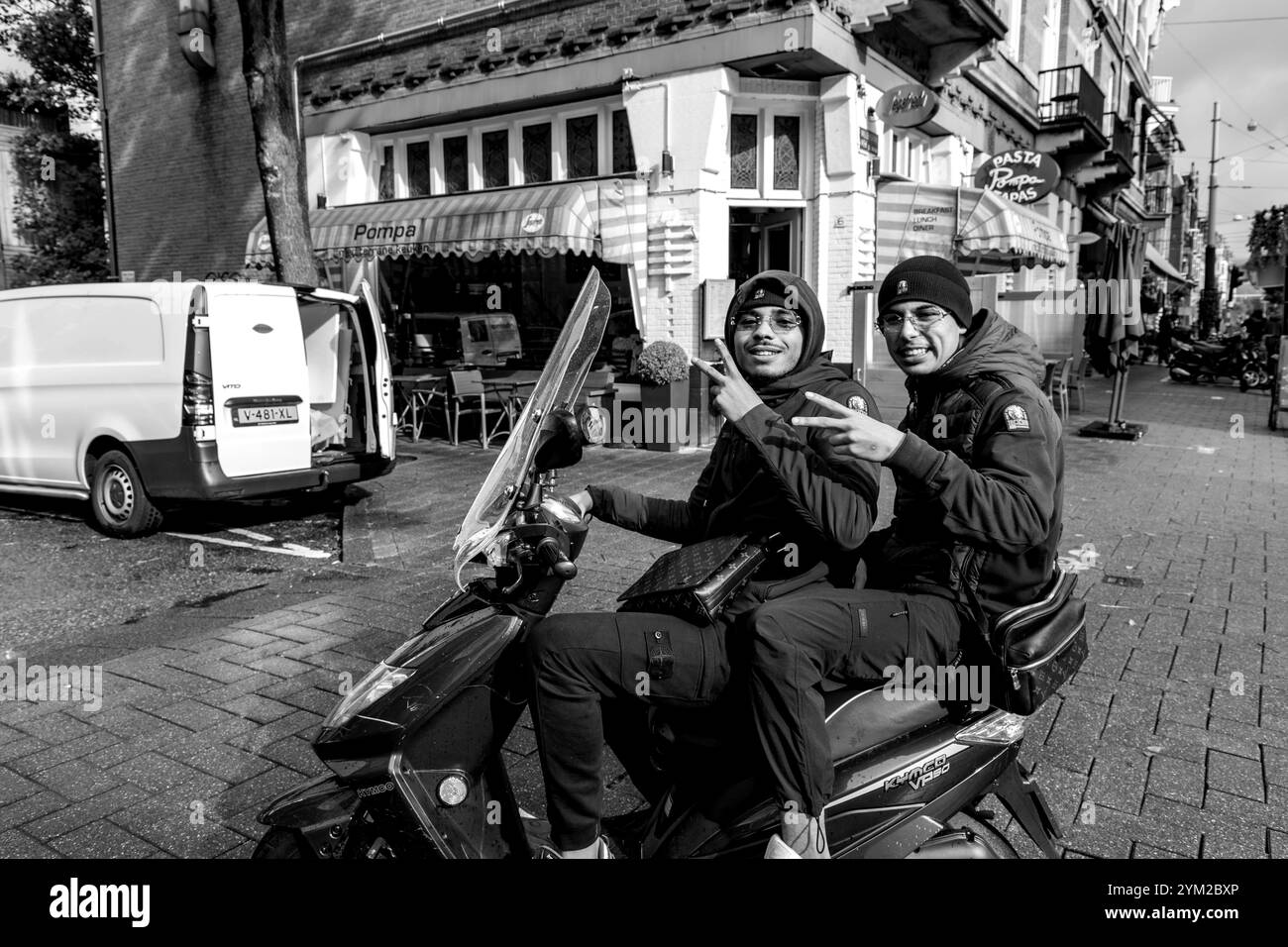 Amsterdam, Niederlande - 17. Oktober 2021: Nicht identifizierte junge Männer fahren auf einem Motorrad in den Straßen von Amsterdam. Radfahren ist die Hauptart der Trans Stockfoto