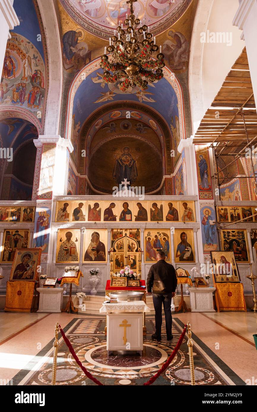 In einer ruhigen orthodoxen Kirche mit atemberaubenden Wandmalereien und Ikonostase. Stockfoto