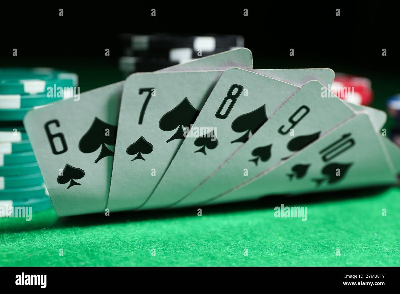 Spielkarten und Pokerchips auf grünem Tisch, Nahaufnahme Stockfoto