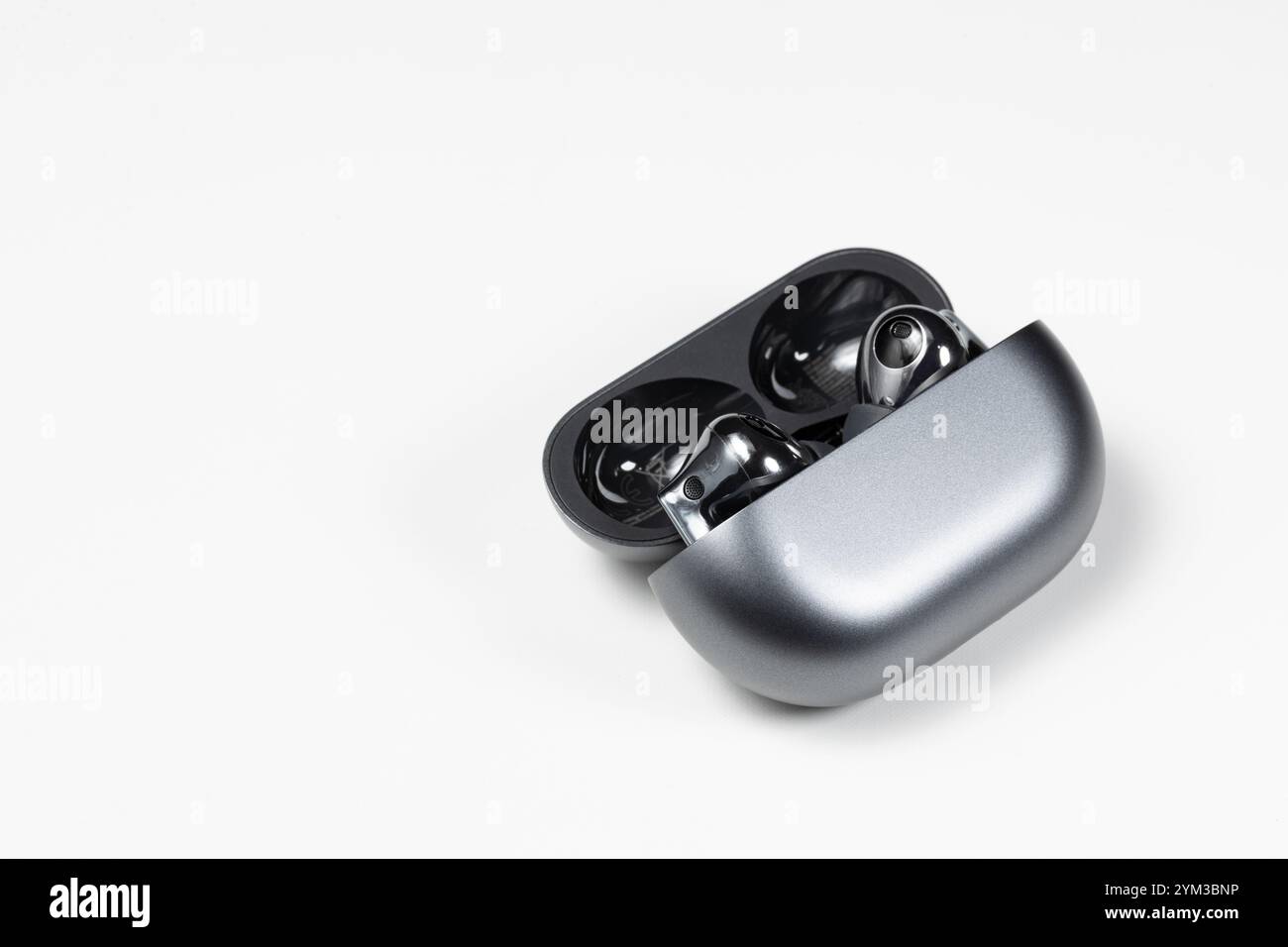 Luxuriöse bluetooth-Kopfhörer oder -Ohrstöpsel oder Kopfhörer mit Ladetasche auf weißem Hintergrund. Stockfoto