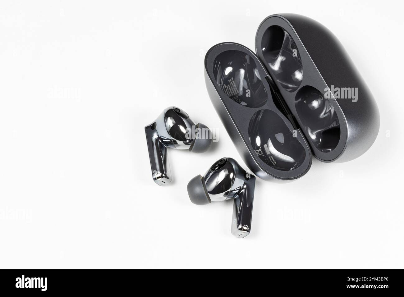 Luxuriöse bluetooth-Kopfhörer oder -Ohrstöpsel oder Kopfhörer mit Ladetasche auf weißem Hintergrund. Stockfoto