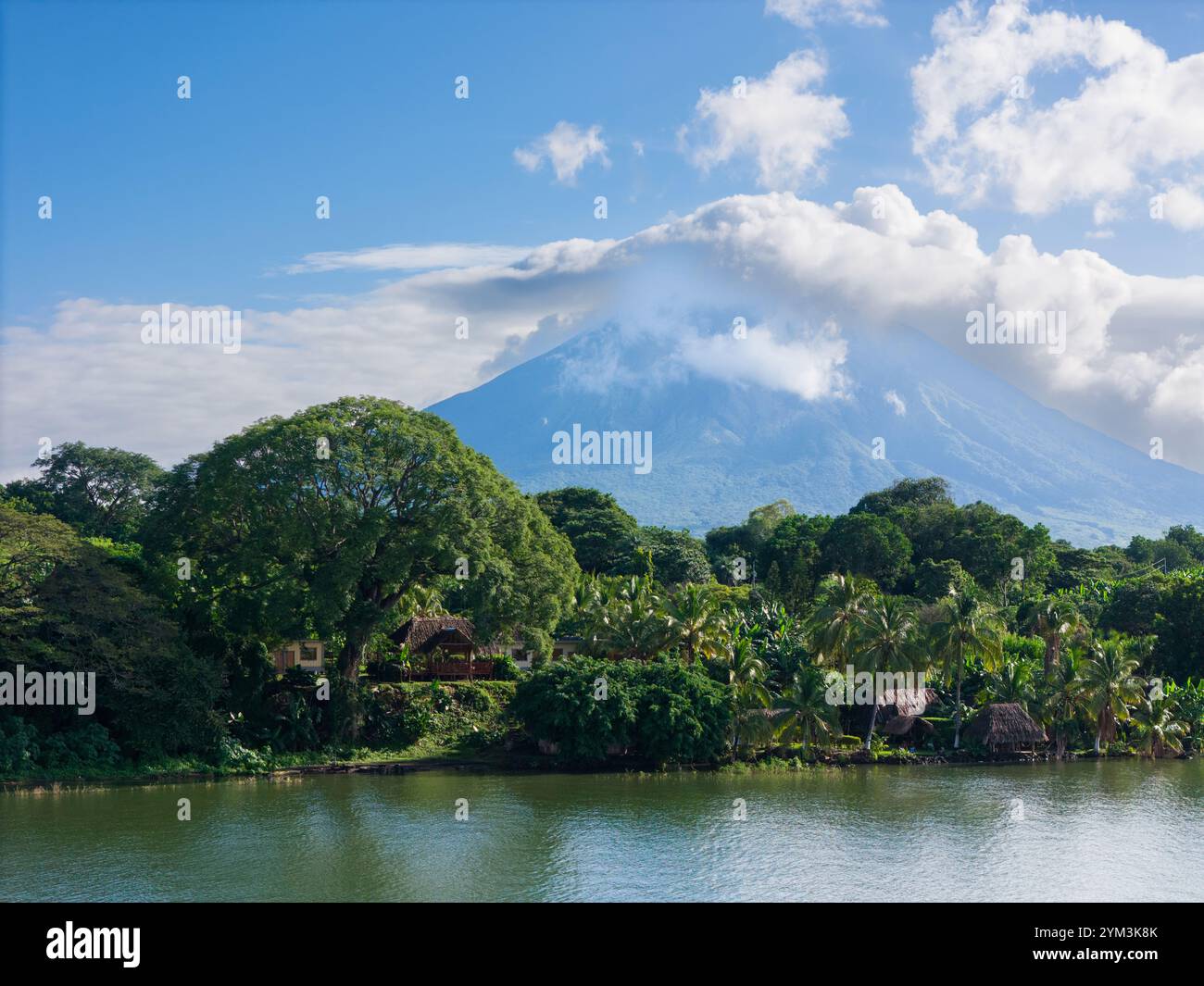 Der atemberaubende Vulkan überragt die pulsierende Landschaft mit Grün und ruhigem Wasser und zeigt die Schönheit der Natur. Stockfoto