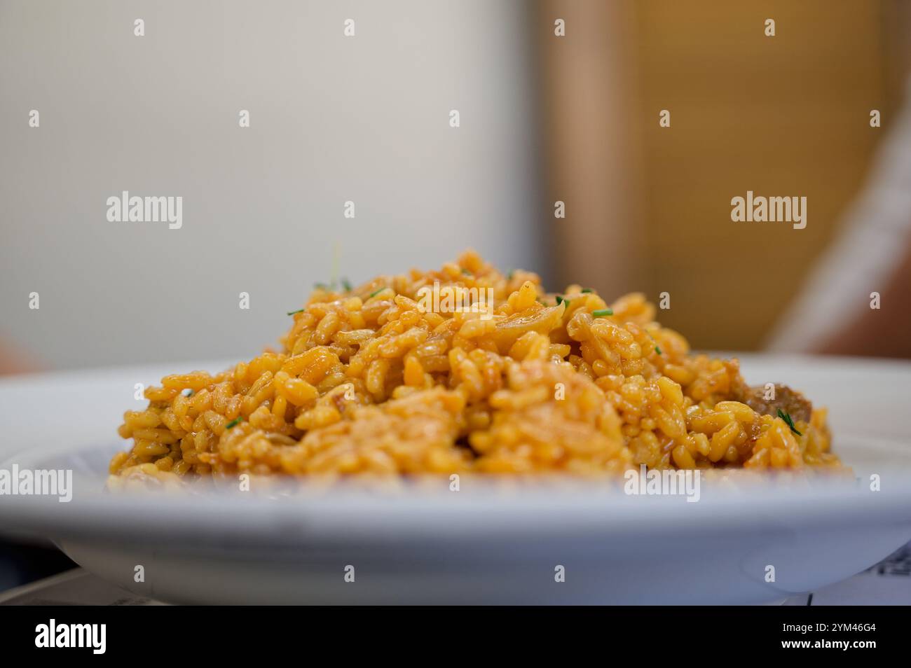 Ein Teller mit reichhaltigem, cremigem Safranrisotto, serviert in einem Restaurant in Granada Stockfoto