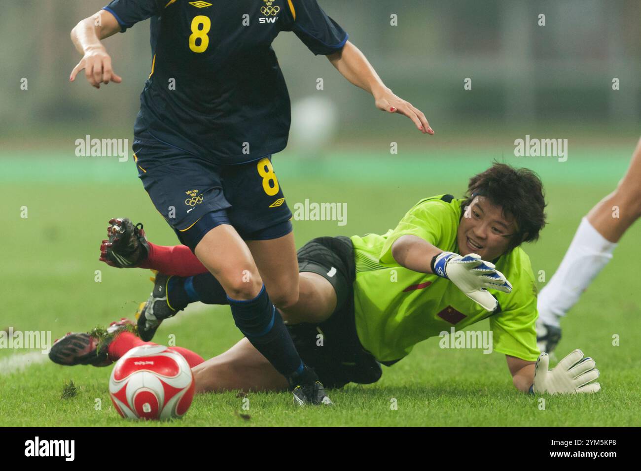 TIANJIN, CHINA - 6. AUGUST: Torhüter Zhang Yanru aus China versucht, bei einem Gruppenspiel beim Olympischen Frauenfußballturnier in Peking am 6. August 2008 in Tianjin, China, gegen die schwedische Lotta Schelin zu sparen. Nur redaktionelle Verwendung. (Foto: Jonathan Paul Larsen / Diadem Images) Stockfoto