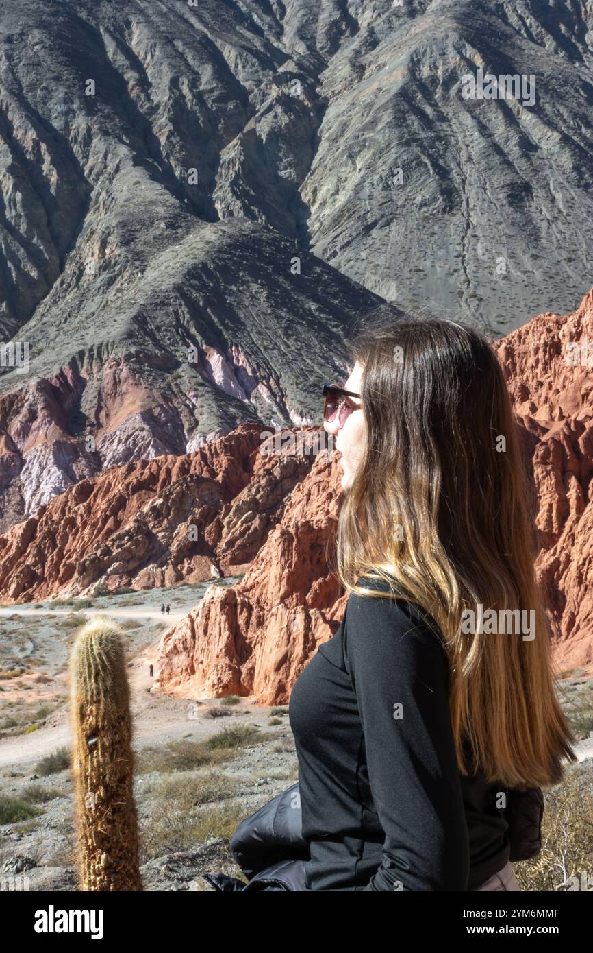 Junge blonde Frau, die die Berglandschaft in Purmamarca, Jujuy, Arg genießt. Stockfoto