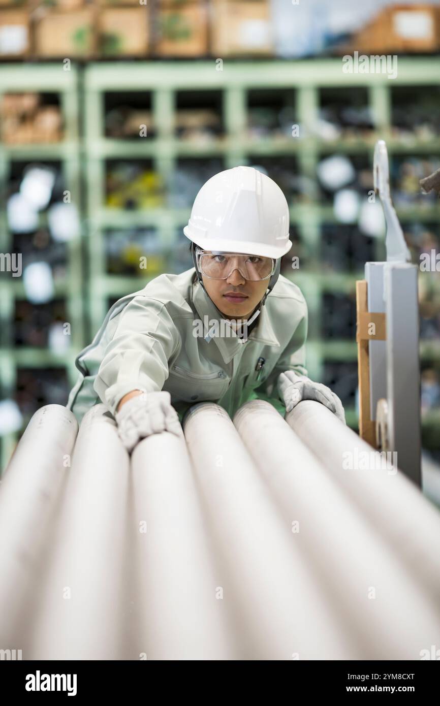 Mann in Arbeitskleidung, der im Lager arbeitet Stockfoto