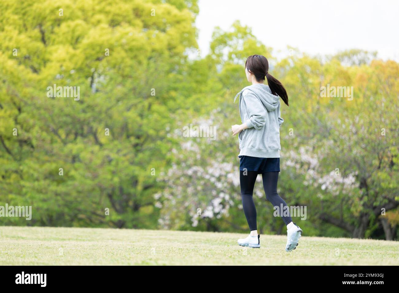 Eine junge Frau, die in einem Naturpark läuft Stockfoto