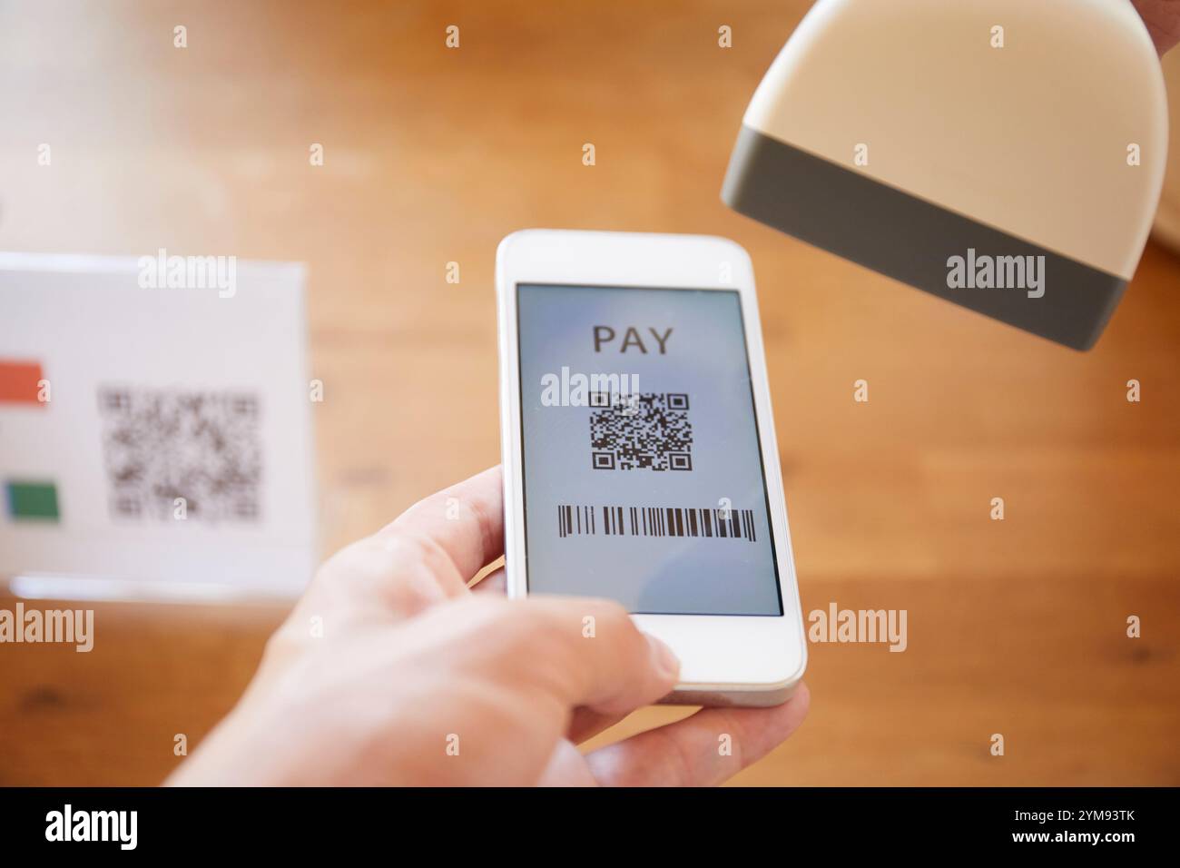 Hände an der Kasse mit einem Smartphone, um eine Zahlung zu tätigen Stockfoto