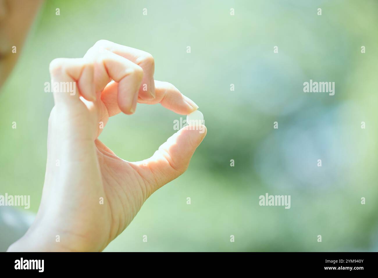 Junge Frau, die Medizin in der Hand hält Stockfoto