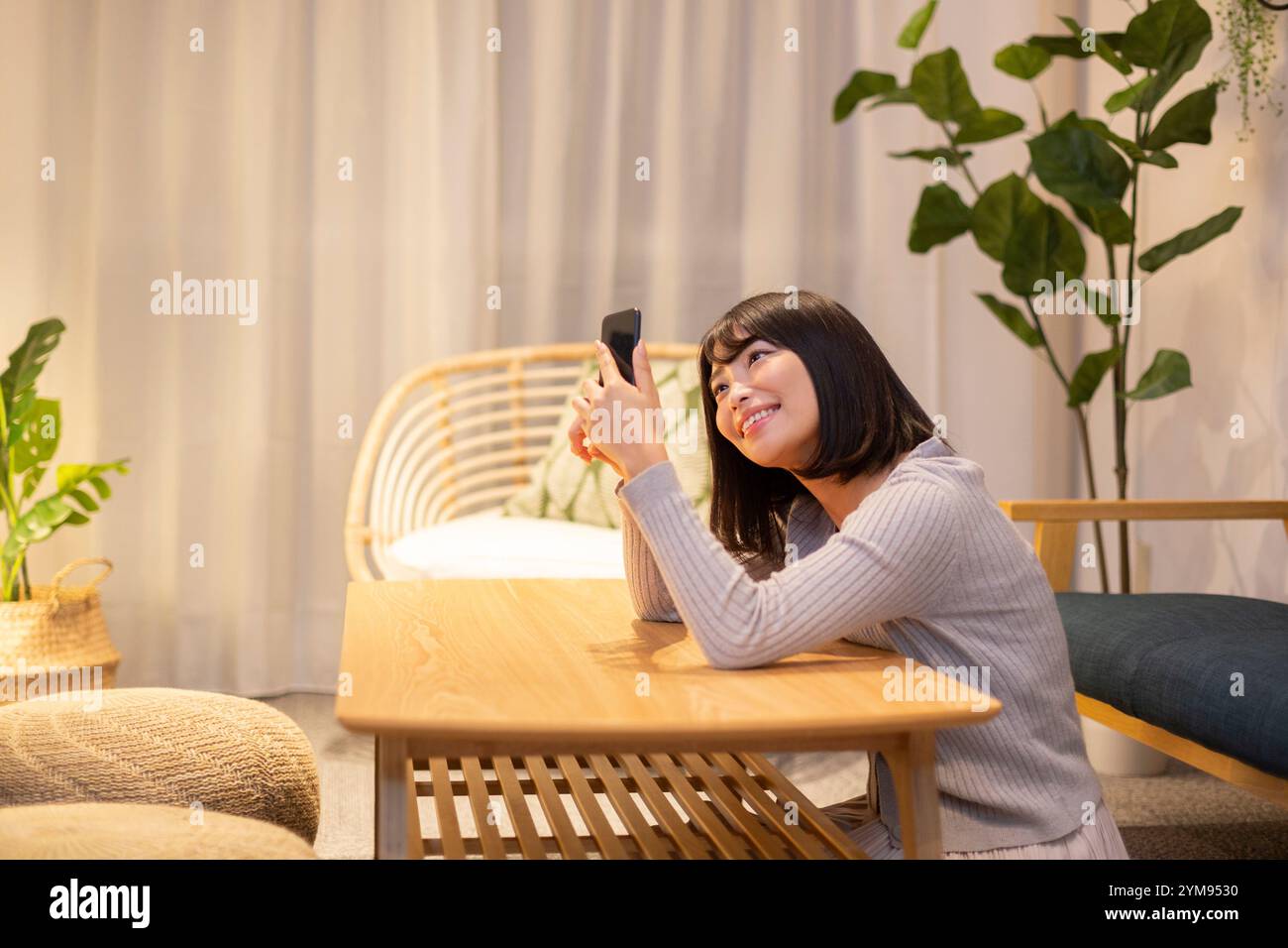 Eine junge Frau, die nachts in ihrem Zimmer relaxt Stockfoto