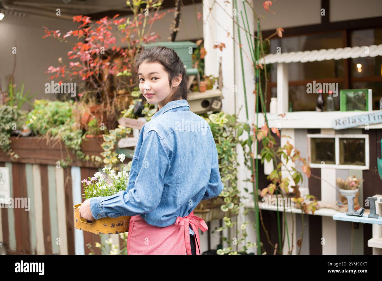 Frau, die mit Blumen zurückblickt Stockfoto