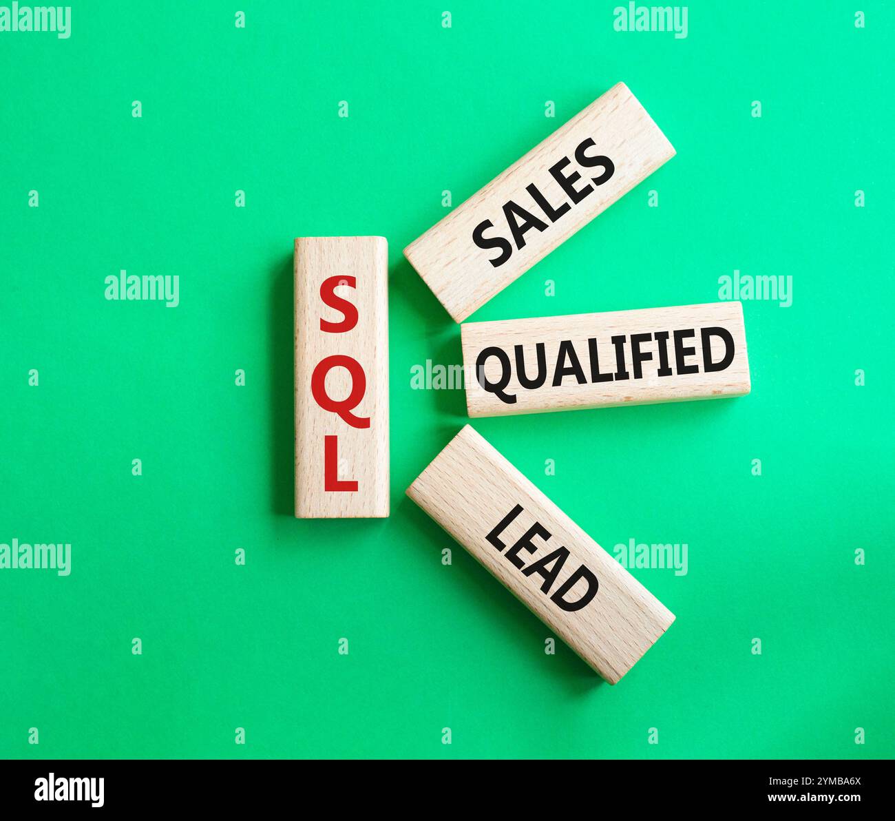 SQL - qualifizierter Lead für Vertrieb. Holzwürfel mit SQL-Wörtern. Schöner grüner Hintergrund. Business- und SQL-Konzept. Kopierbereich. Stockfoto