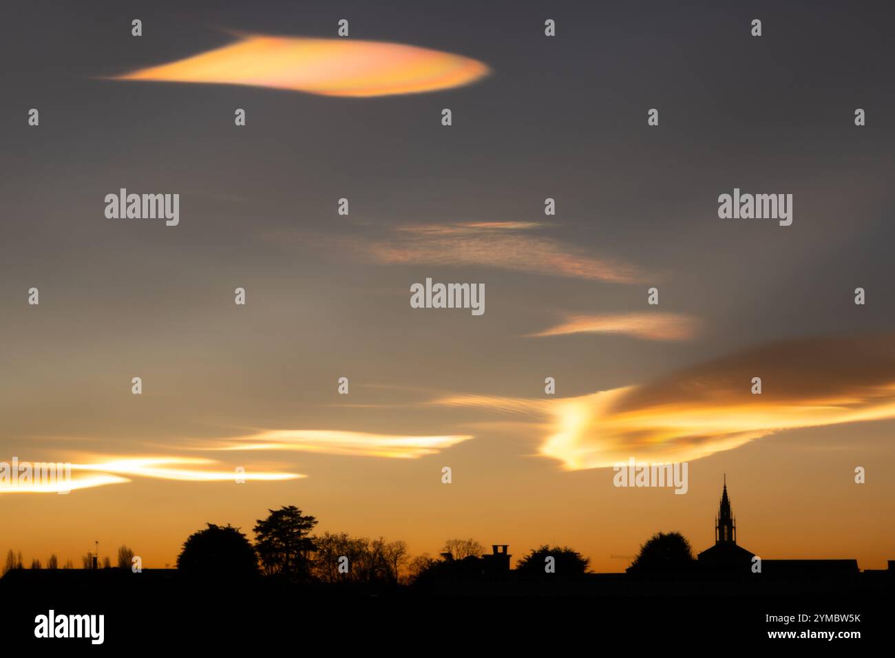 Schillernde Wolken während eines wunderschönen Wintersonnenverkehrs über der Stadt. Stockfoto
