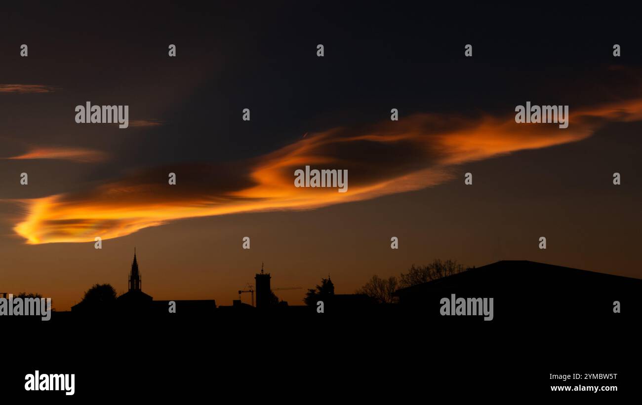 Schillernde Wolken während eines wunderschönen Wintersonnenverkehrs über der Stadt. Stockfoto