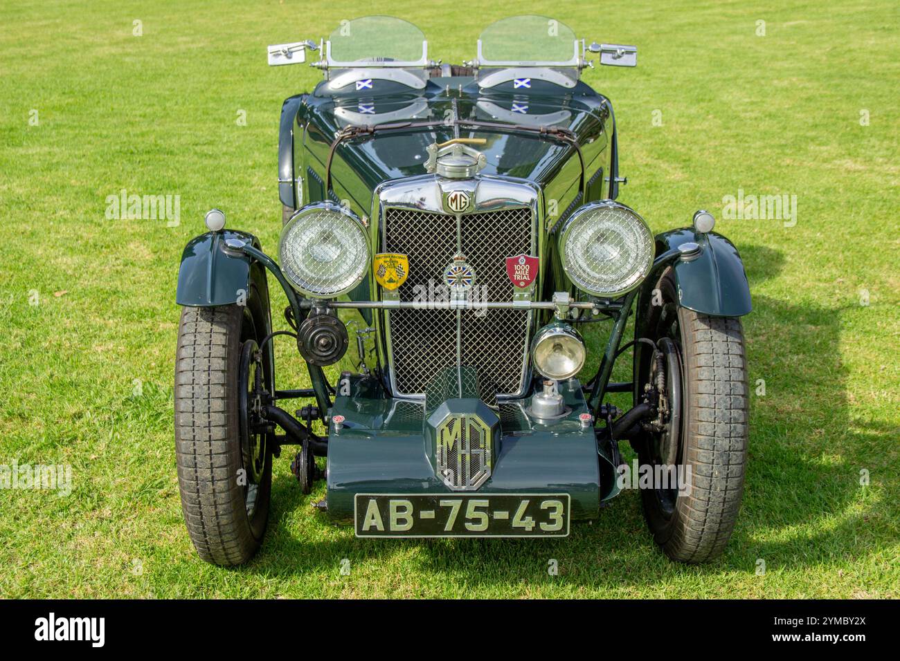 Vorderansicht eines klassischen mg-Sportwagens, der auf einem grünen Rasen geparkt ist und sein klassisches Design und seine britische Tradition zeigt Stockfoto