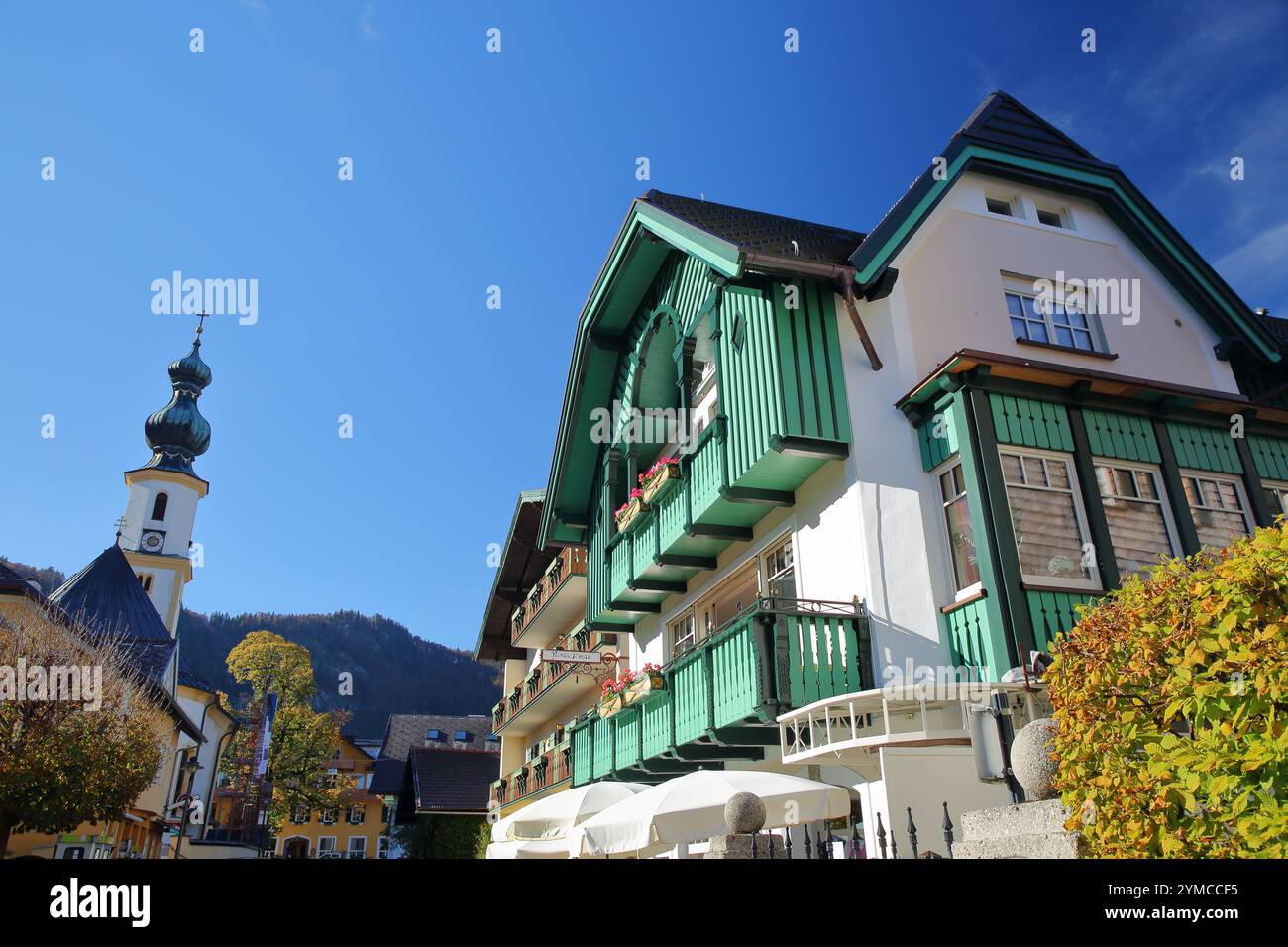 Die Egidiuskirche und die bunten traditionellen Holzhäuser in St. Gilgen, Wolfgangsee, Salzkammergut, Steiermark, Österreich, Europa Stockfoto